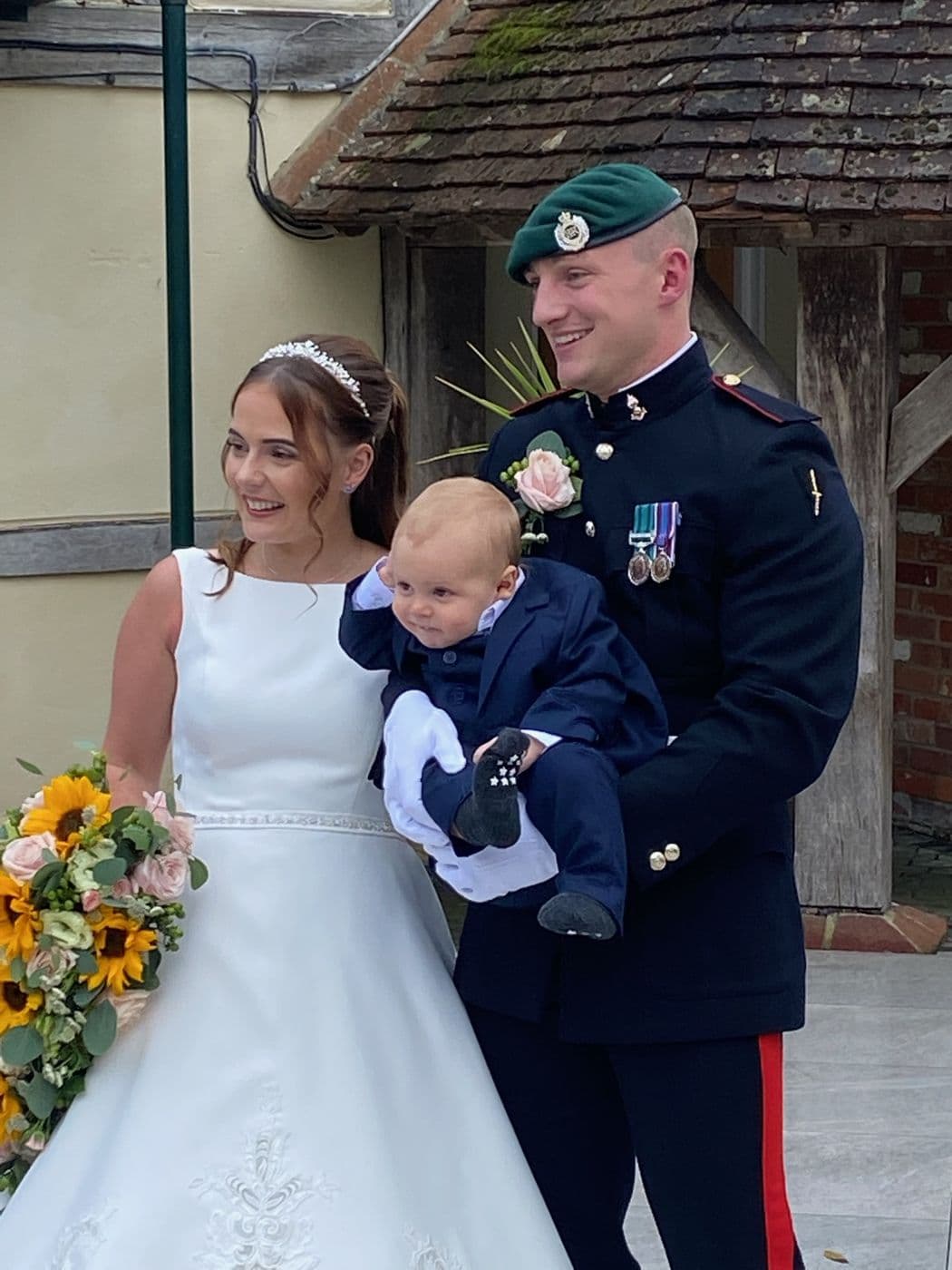 Harry Hatfield in dress uniform on his wedding day, holding his son